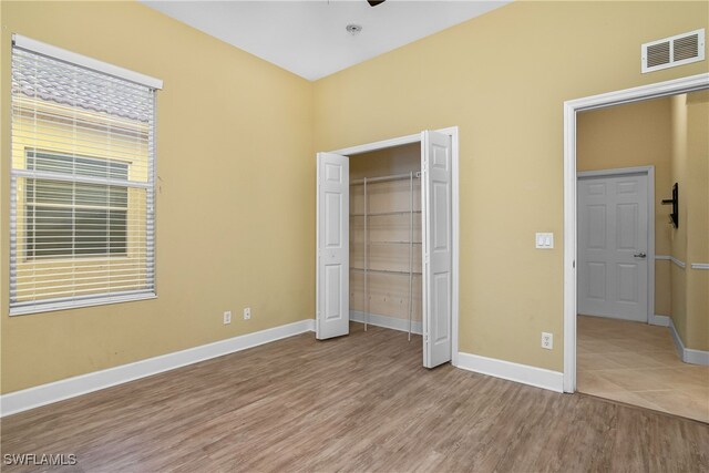 unfurnished bedroom with light hardwood / wood-style floors and a closet