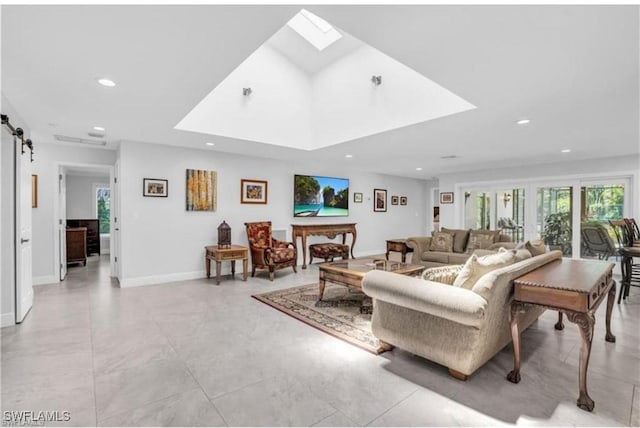 living room featuring a barn door and a skylight