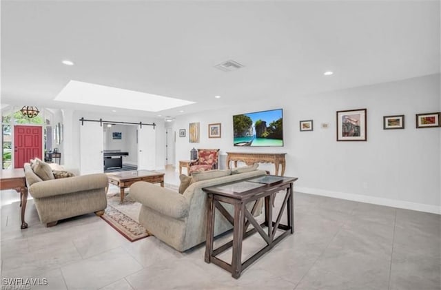 living room with a barn door and a skylight