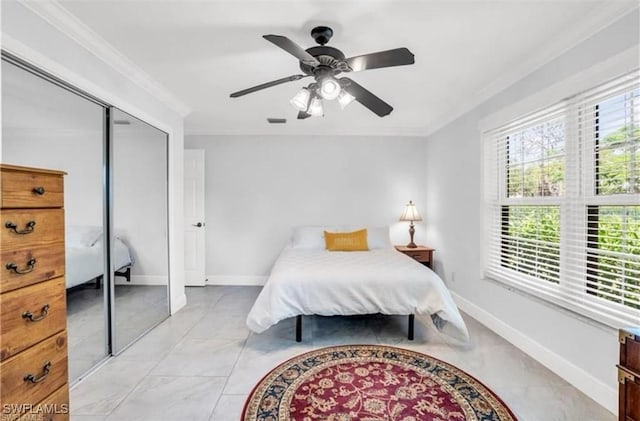 bedroom featuring a closet, ceiling fan, and crown molding