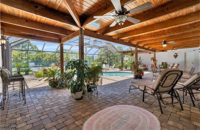 view of patio with ceiling fan and a lanai