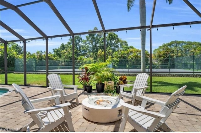 view of patio with glass enclosure and a fire pit