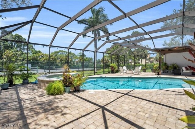 view of swimming pool featuring a patio area and a lanai