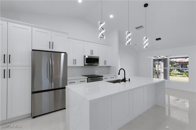 kitchen featuring sink, stainless steel appliances, pendant lighting, lofted ceiling, and white cabinets