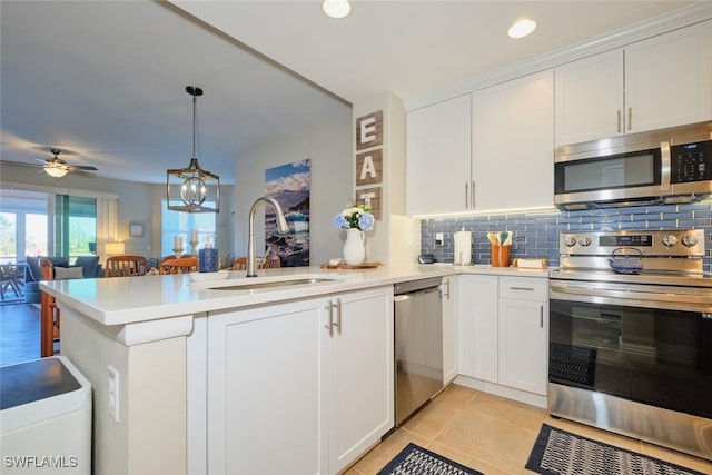 kitchen featuring kitchen peninsula, stainless steel appliances, white cabinetry, and sink