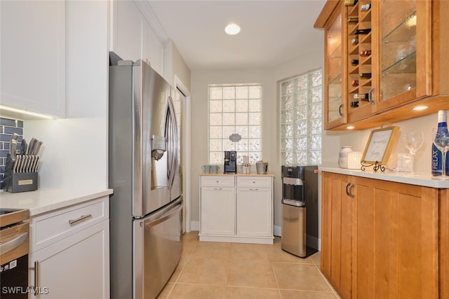 kitchen featuring white cabinets, light tile patterned floors, and stainless steel refrigerator with ice dispenser