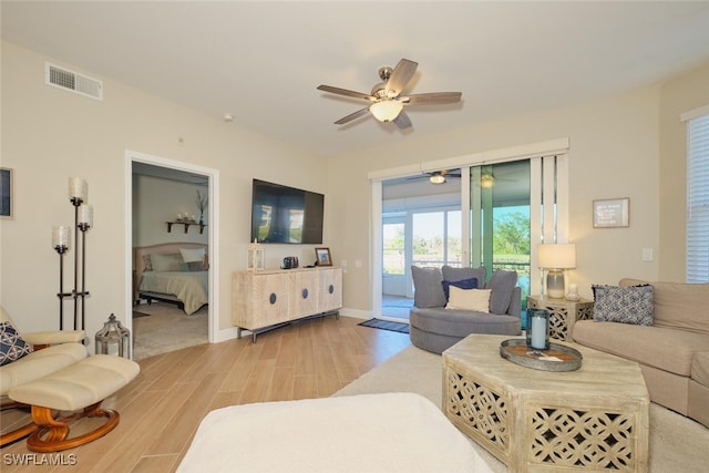 living room with light hardwood / wood-style flooring and ceiling fan