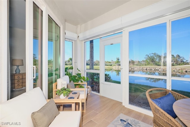 sunroom / solarium featuring a water view