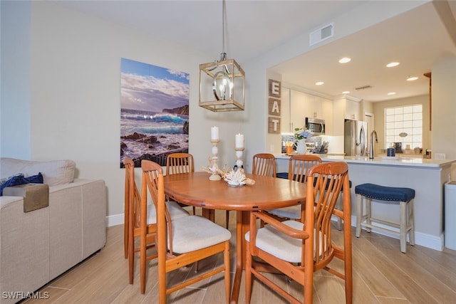 dining area featuring a chandelier and light hardwood / wood-style flooring