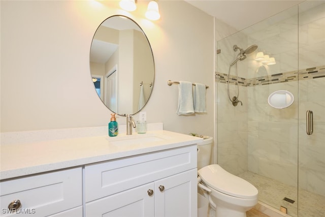 bathroom featuring vanity, toilet, and a shower with shower door