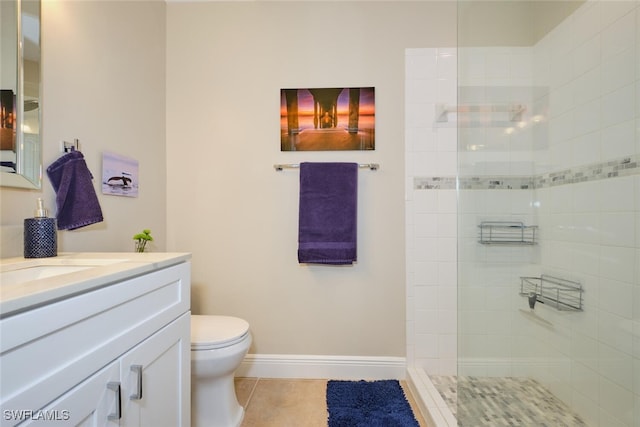 bathroom featuring tile patterned flooring, vanity, tiled shower, and toilet