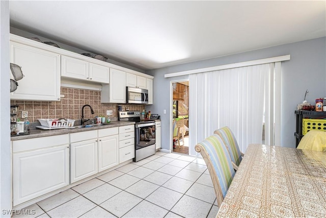 kitchen with white cabinets, stainless steel appliances, tasteful backsplash, and sink