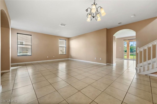 empty room featuring light tile patterned flooring and an inviting chandelier