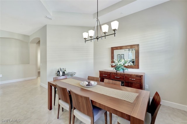 tiled dining space featuring a chandelier