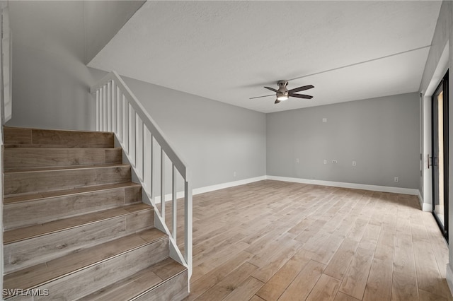 staircase featuring hardwood / wood-style flooring and ceiling fan