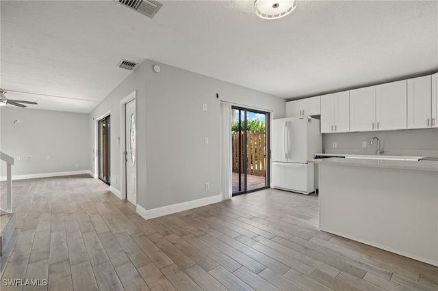 kitchen featuring ceiling fan, sink, light hardwood / wood-style flooring, white fridge, and white cabinetry