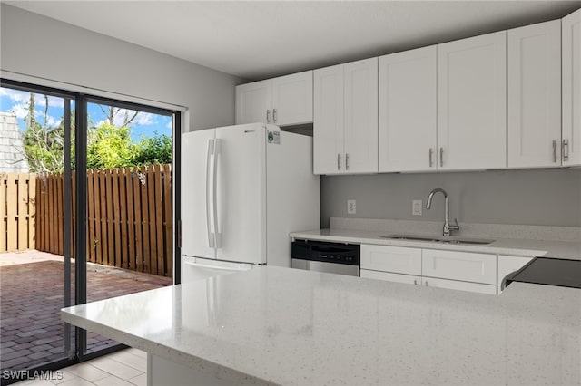 kitchen with white cabinetry, dishwasher, sink, light stone countertops, and white fridge