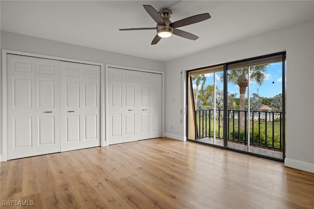 unfurnished bedroom with access to outside, light wood-type flooring, two closets, and ceiling fan