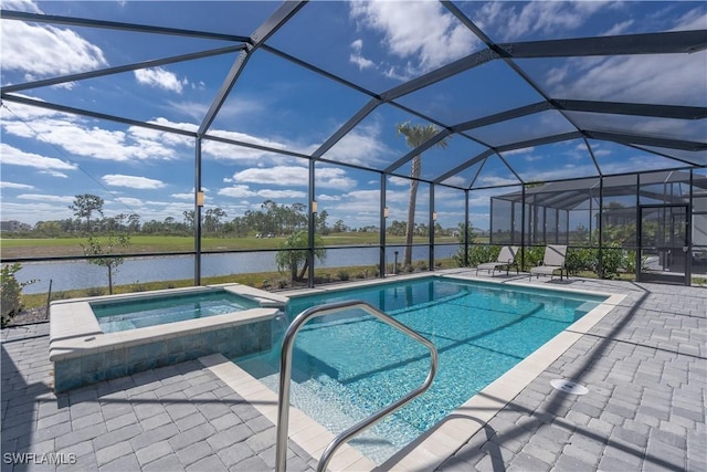 view of pool with an in ground hot tub, a water view, glass enclosure, and a patio area