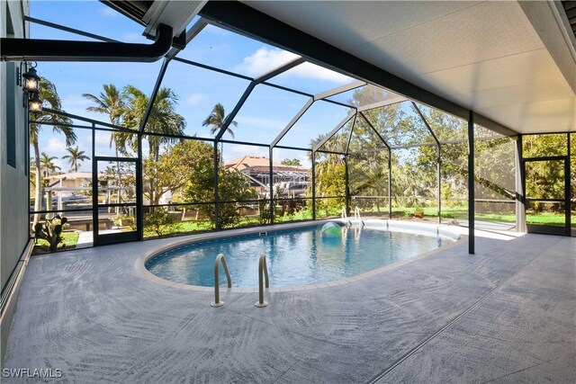 view of pool featuring glass enclosure and a patio