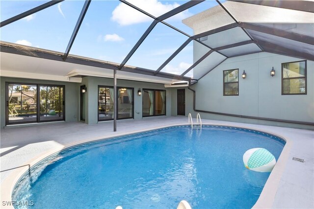 view of swimming pool with a patio area and glass enclosure