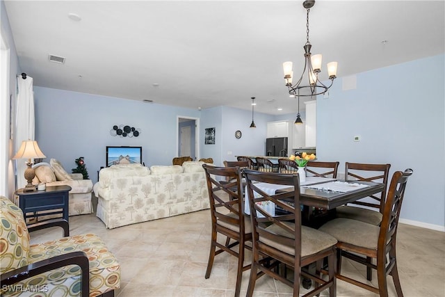 dining area featuring a chandelier and light tile patterned floors