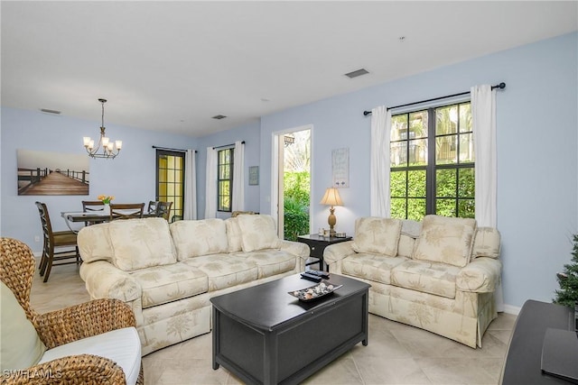 living room with light tile patterned floors and a notable chandelier