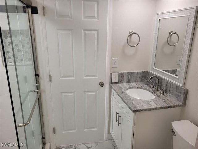 bathroom with vanity, toilet, and a shower with door