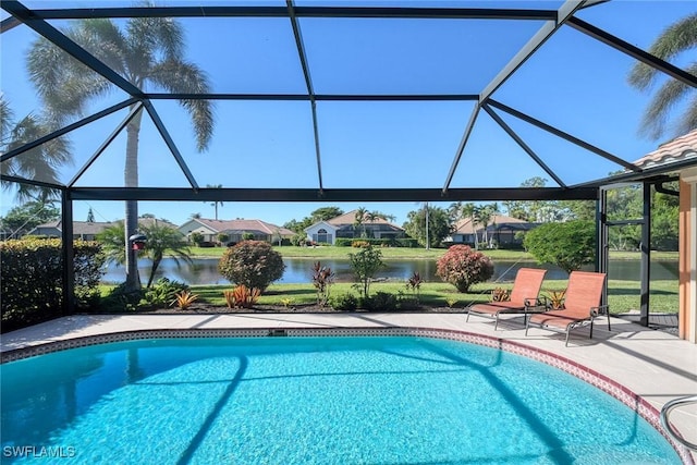 view of pool featuring a patio, a water view, and glass enclosure