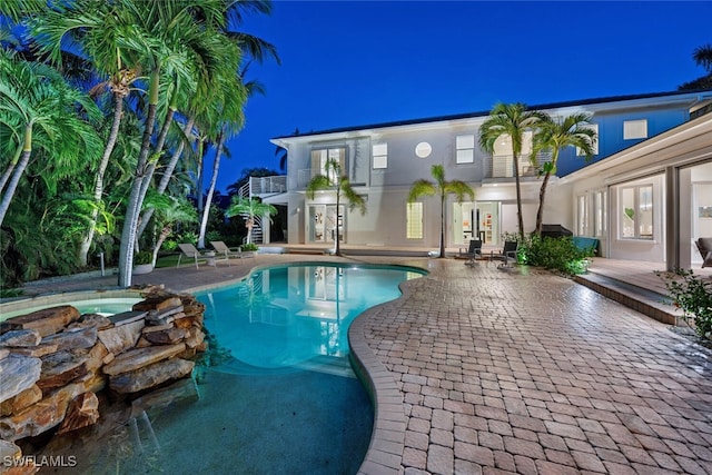 view of pool featuring a patio area, an in ground hot tub, and french doors