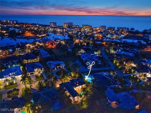 aerial view at dusk featuring a water view