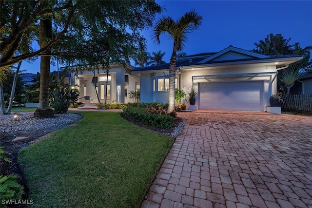 ranch-style house with a garage and a yard