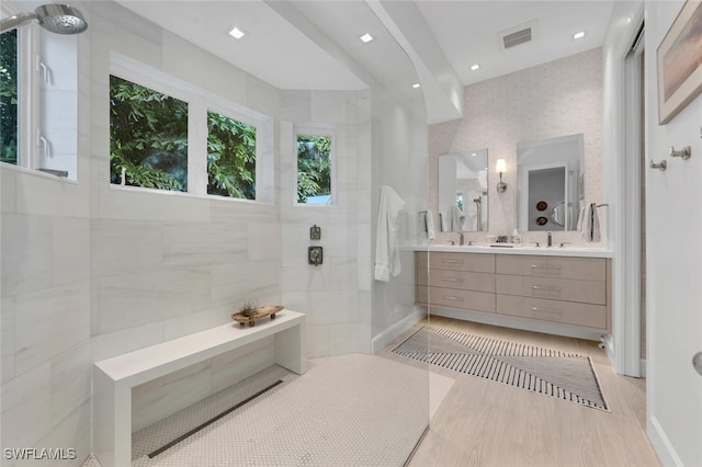 bathroom featuring tiled shower, hardwood / wood-style floors, and vanity