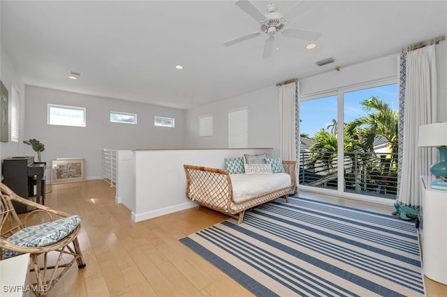 living area featuring ceiling fan, light wood-type flooring, and a wealth of natural light