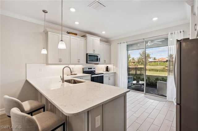 kitchen featuring a breakfast bar, kitchen peninsula, decorative light fixtures, white cabinetry, and stainless steel appliances