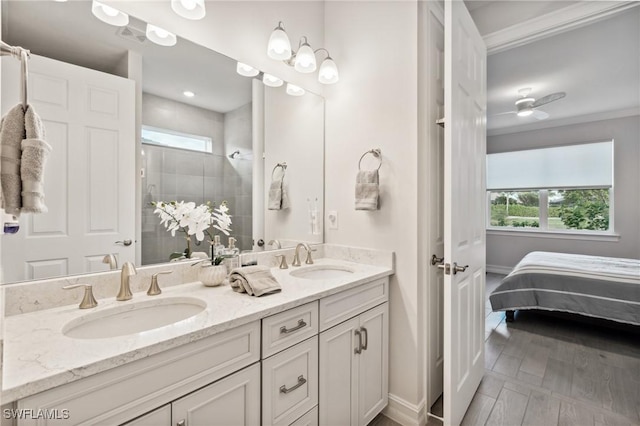 bathroom with hardwood / wood-style floors, vanity, a shower, and crown molding