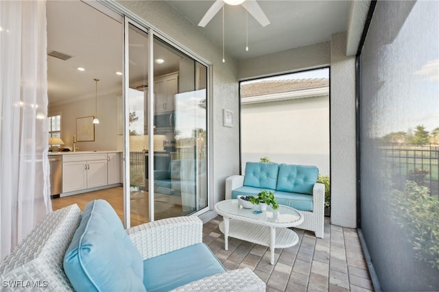 sunroom with ceiling fan and sink