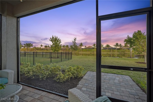 sunroom featuring a water view