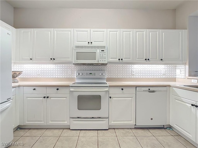 kitchen featuring decorative backsplash, white cabinetry, and white appliances