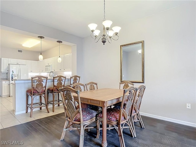 tiled dining room featuring an inviting chandelier