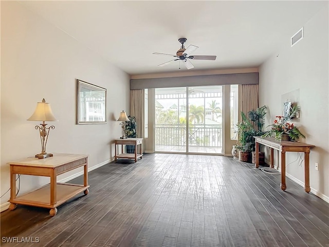 living area featuring ceiling fan and dark hardwood / wood-style floors