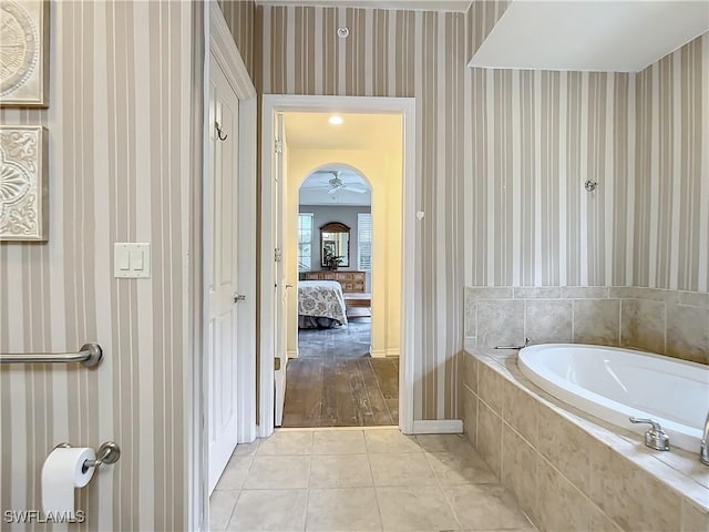 bathroom featuring tile patterned flooring, ceiling fan, and tiled tub