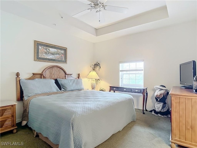 bedroom featuring carpet flooring, ceiling fan, and a tray ceiling