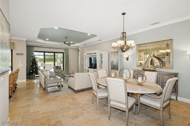 dining space featuring ceiling fan with notable chandelier, a tray ceiling, and crown molding