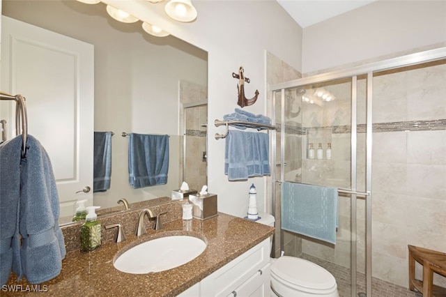 bathroom featuring vanity, toilet, and an enclosed shower