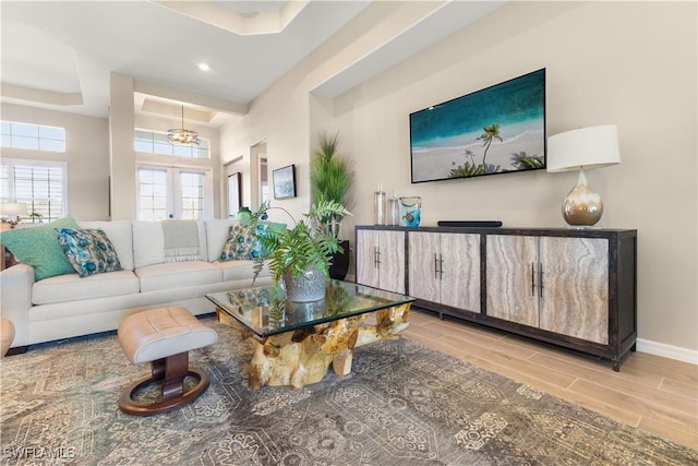 living room with light hardwood / wood-style floors and a raised ceiling