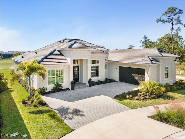 15844 Cranes Marsh Ct, Punta Gorda, FL 33982 - view of front of home with decorative driveway, an attached garage, a tile roof, a front lawn, and stucco siding