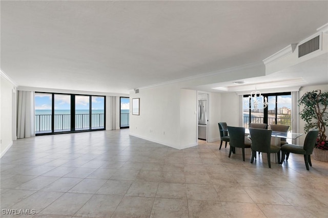 tiled dining space with expansive windows, crown molding, and a water view