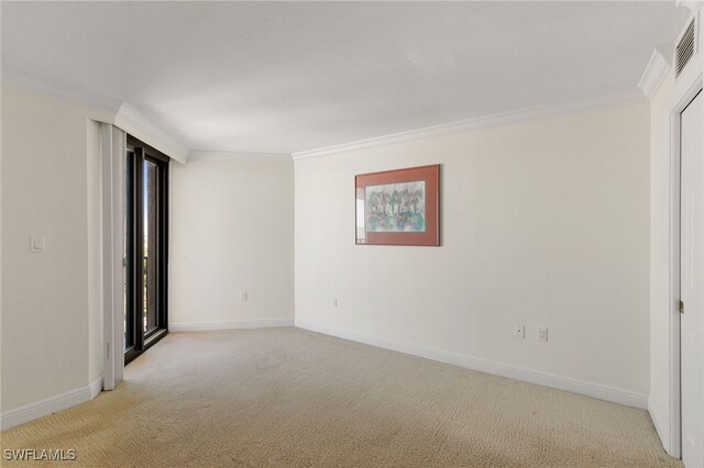 carpeted spare room featuring crown molding