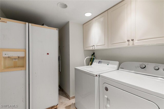 laundry area featuring washer and dryer and cabinets